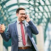 Businessman using mobile phone outside of office buildings in th Life on the Road - Sales Voice to CRM